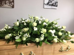 Veneered Coffin with floral tribute supplied by Albert Parr in Beckenham