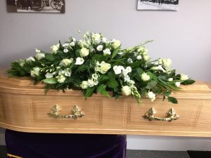 Veneered Coffin with floral tribute supplied by Albert Parr in Beckenham